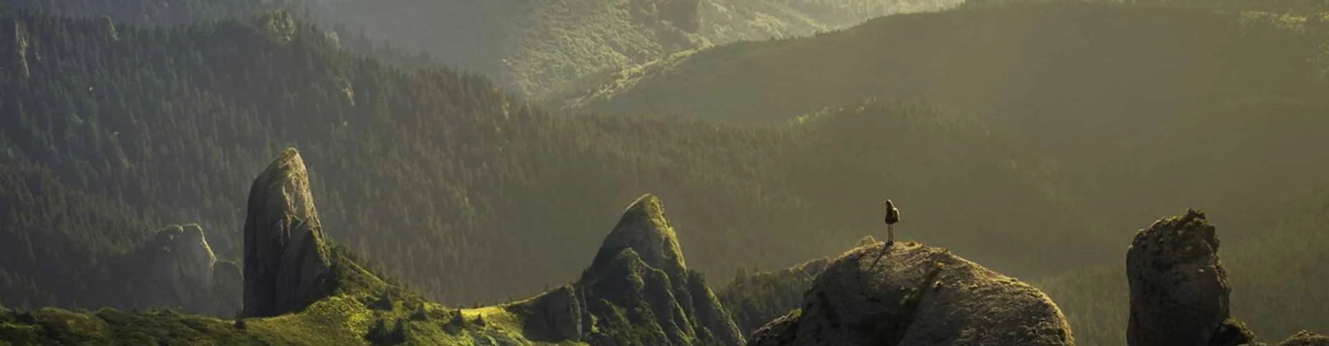planinar na ivici dijela sa prostranim zelenim planinskim pejzažem